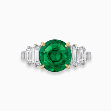 Round Colombian emerald engagement ring with trapezoid diamonds in platinum and 18K yellow gold