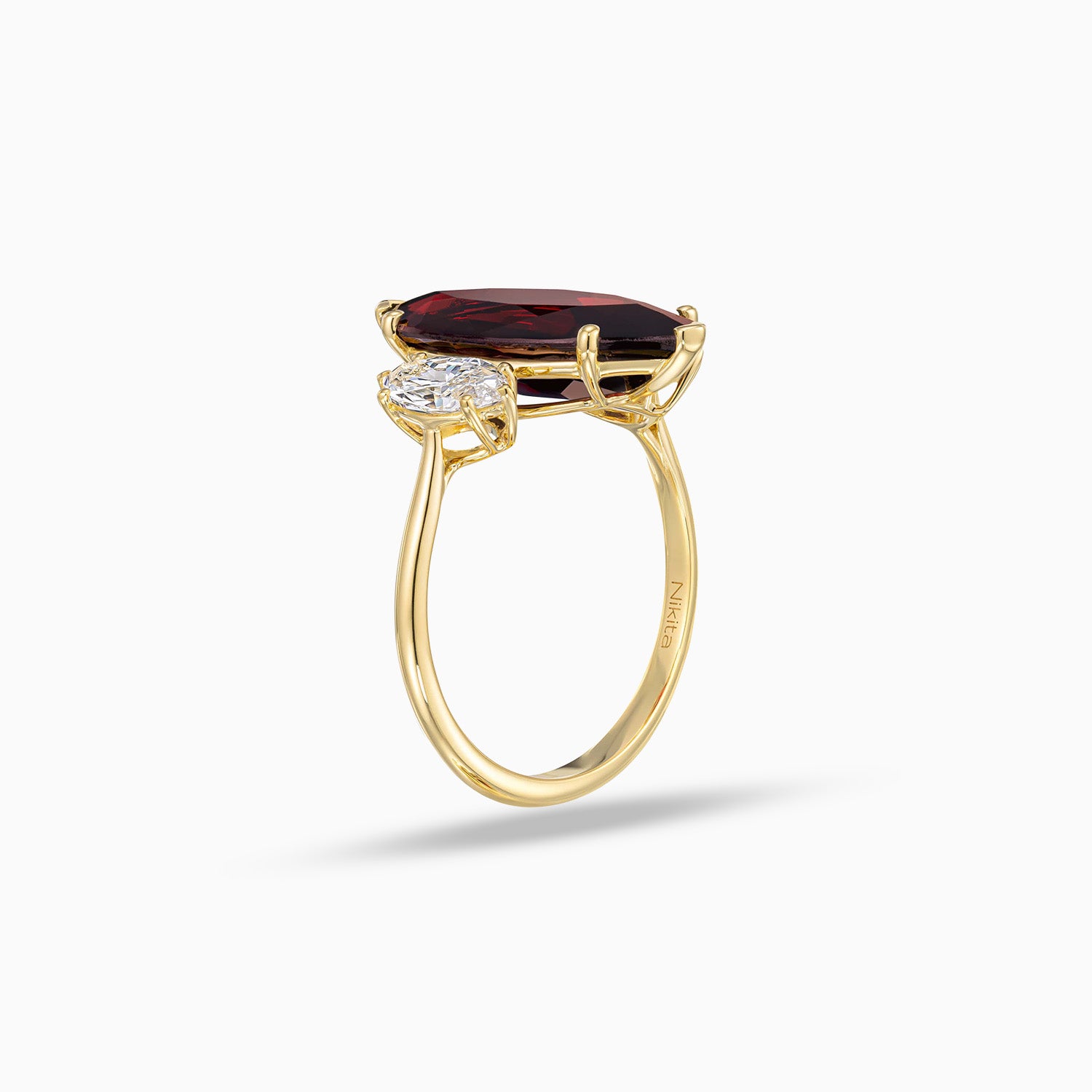 Side view of marquise garnet ring with marquise shape diamonds in 18K yellow gold