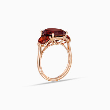 Side view of oval garnet ring with half moon garnet side stones in 18K rose gold