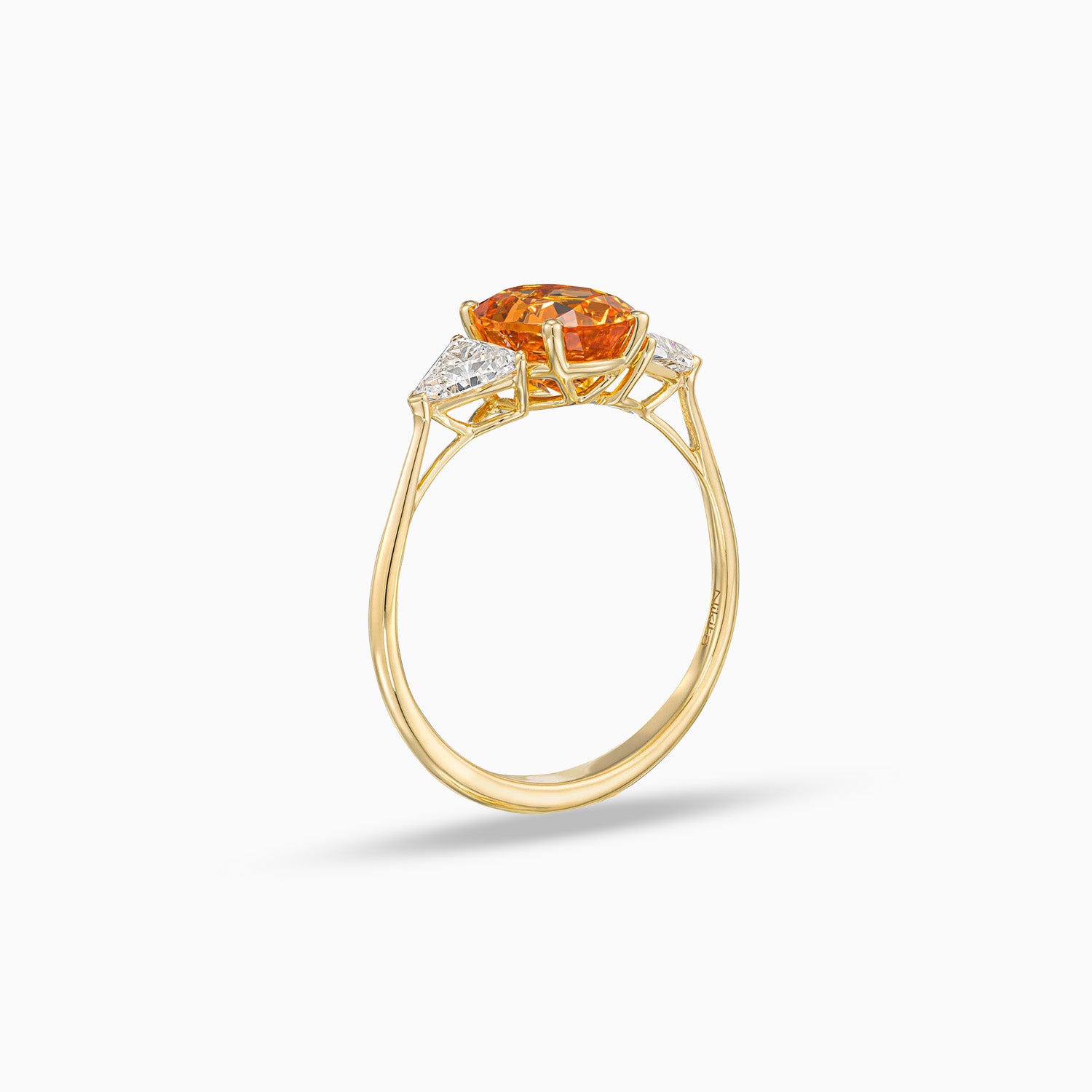 Side view of oval shape spessartite garnet ring with trillion cut diamonds in 18K yellow gold